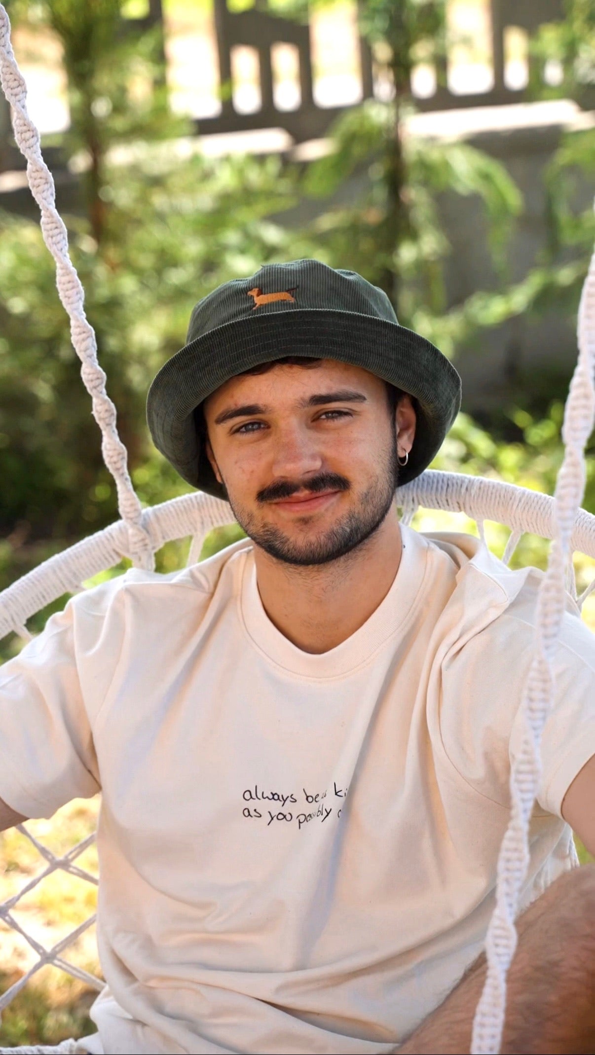 Junger Mann trägt Dackel Fischerhut aus grünem Cord mit gesticktem Dackelmotiv